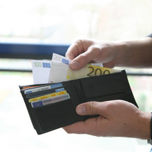 Eine Person hält Geldscheine in den Händen