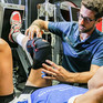 Ein Sportphysiotherapeut behandelt eine Sportlerin.