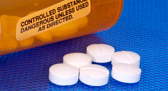 Nebenwirkungen Narkotika Man sieht einen Tablettenbehälter und Tabletten die davor liegen