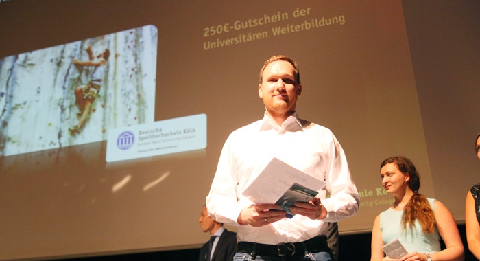 Dr. Sebastian Schwab mit einem Gutschein der Universitären Weiterbildung auf dem Absolventenball der Sporthochschule 2015