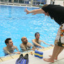 Trainer am Beckenrand mit Schwimmern