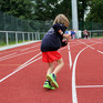Ein Kind läuft in einem Leichtathletikstadion