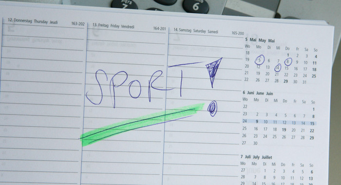 Ein aufgeschlagener Kalender in dem das Wort Sport eingetragen ist