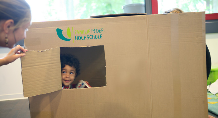 Kind in einem Karton mit Fenster