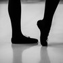 Beine und Füße einer Tänzerin auf dem Tanzboden
