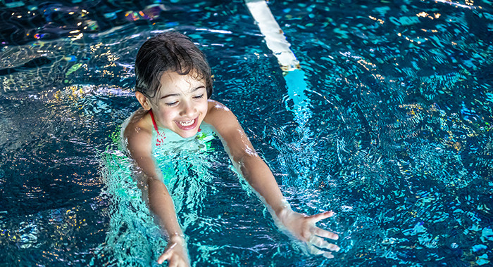 Kind schwimmt im Schwimmbad. 