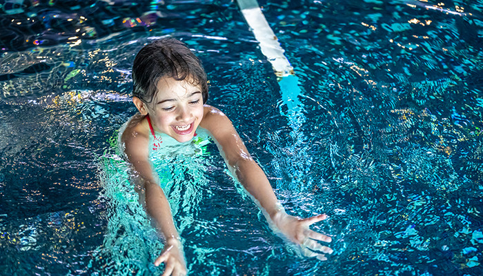 Kind hat Spaß beim Schwimmen im Schwimmbad.