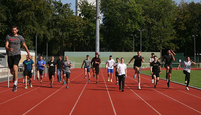 Teilnehmer des DSHS Athletiktrainer auf der Laufbahn der Leichtathletikanlage.