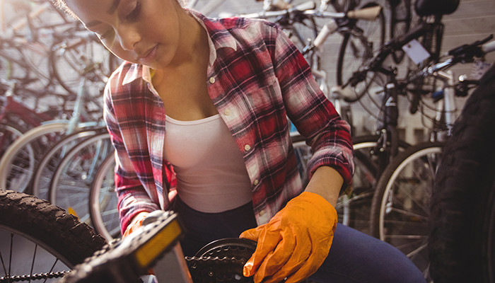 Frau reinigt ein Fahrrad.