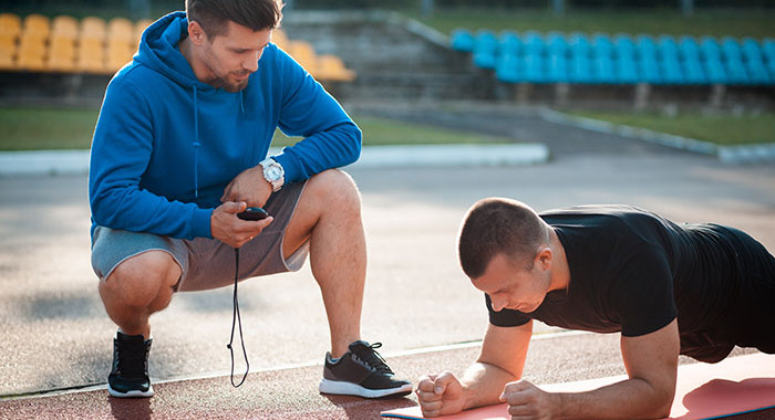 Ein Personal Trainer betreut seinen Sportler. 