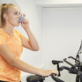 Sportlerin auf Ergometer mit Asthmaspray