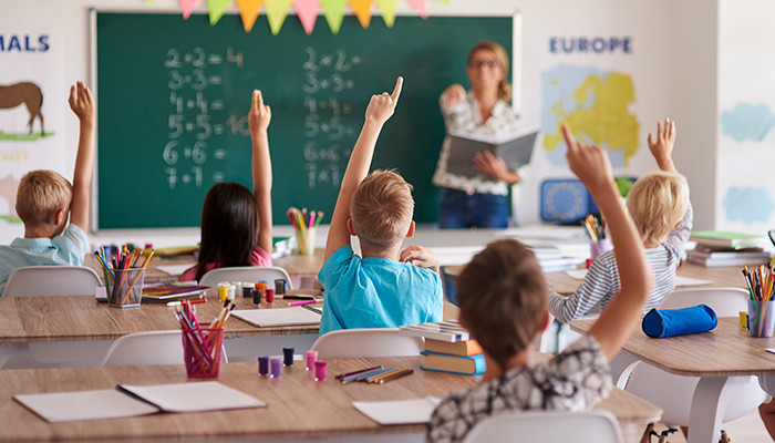 Kinder und Lhererin im Klassenzimmer. 