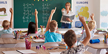 Kinder zeigen auf in einem Klassenzimmer