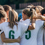 Frauen-Fußballmannschaft bildet einen Kreis.