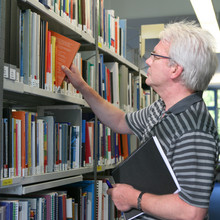 Ein älterer Mann vor einem Bücherregal