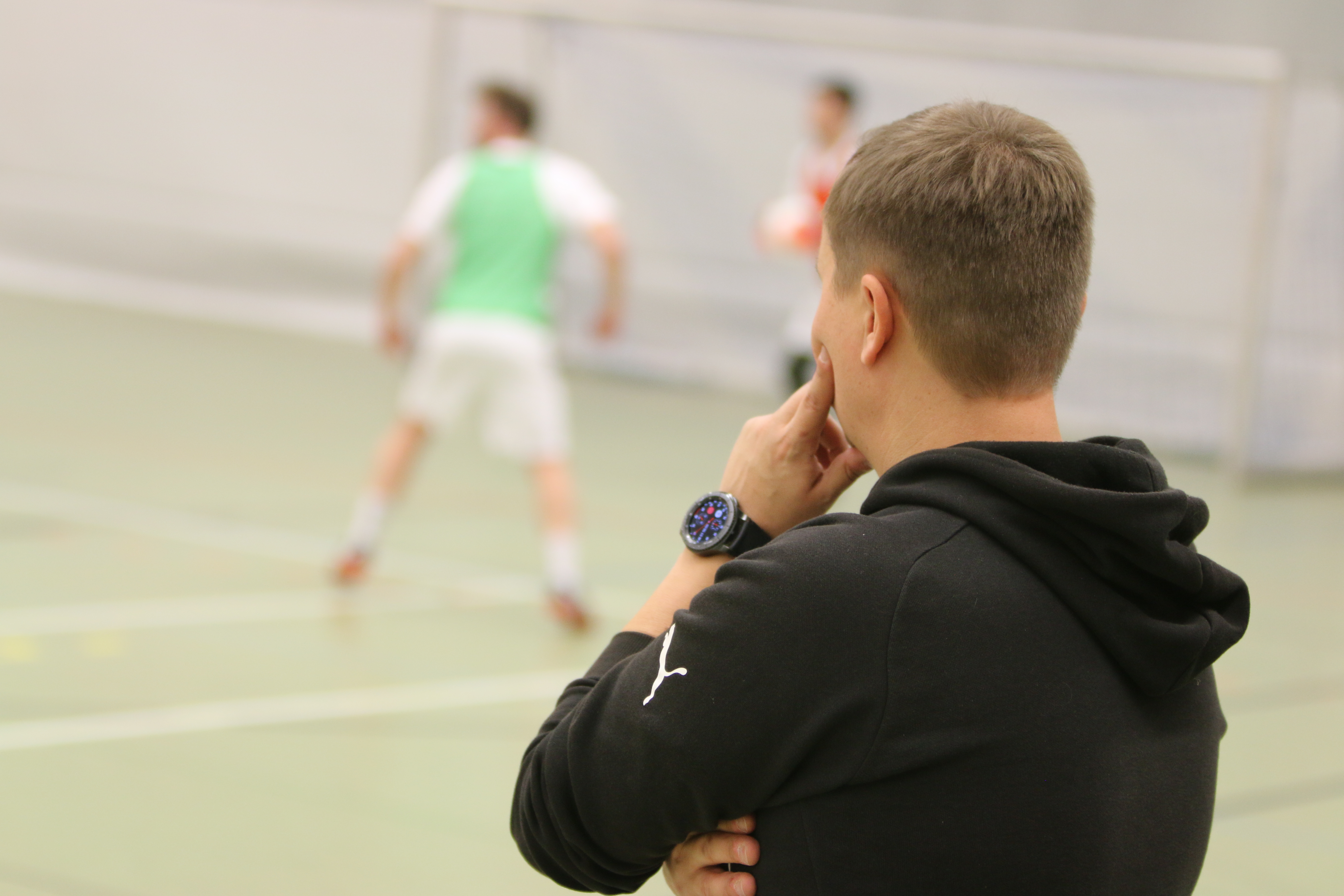 Lehrkraft schaut auf ein Fußballspiel
