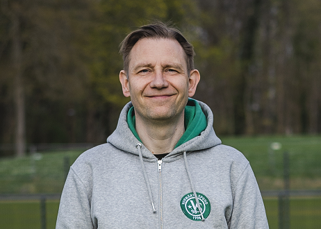 Porträtfoto von Thomas Staack. Er steht in einem grauen Vorwärts-Spoho-Pullover vor einem begrünten Hintergrund.
