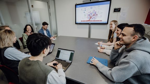 Personen besprechen Präsentation im Konferenzraum
