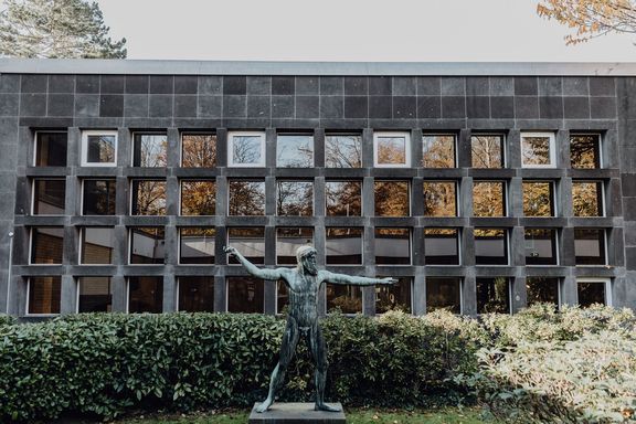 Außenbereich des Campus der Deutsche Sporthochschule mit steinerner Statue
