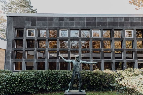 Außenbereich des Campus der Deutsche Sporthochschule mit steinerner Statue
