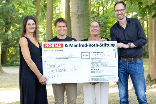 Vier Personen mit einem Scheck