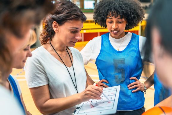 Basketball-Trainerin bei der Taktikbesprechung mit ihrer Mannschaft
