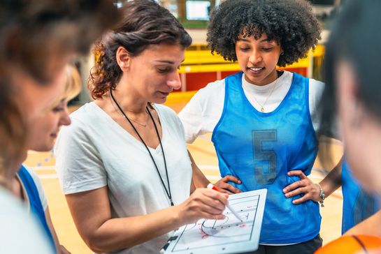 Basketball-Trainerin bei der Taktikbesprechung mit ihrer Mannschaft