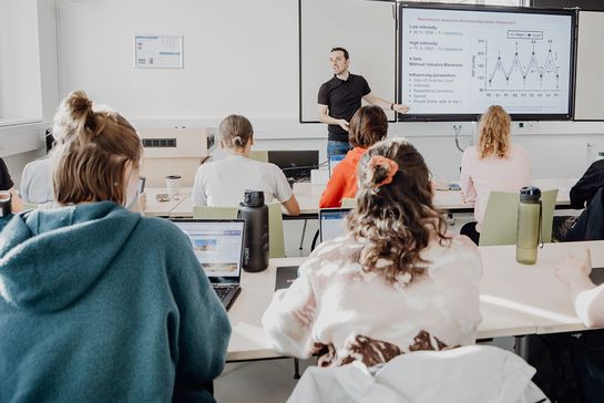 Dozent unterrichtet Studierende im Seminarraum
