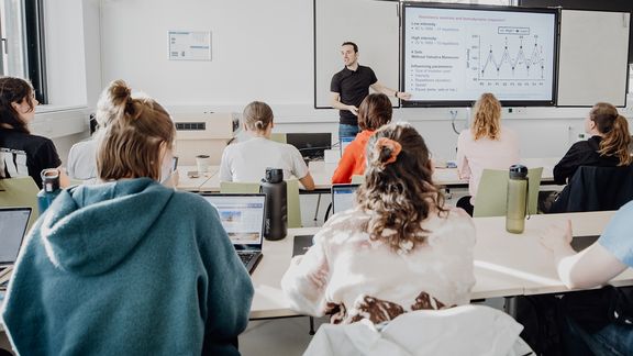 Dozent unterrichtet Studierende im Seminarraum
