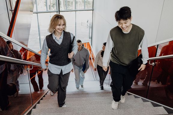 Studierende reden während dem Treppensteigen miteinander

