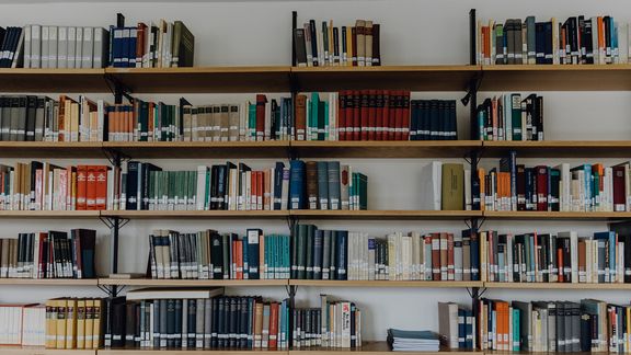Großes Bücherregal, das nicht ganz gefüllt ist
