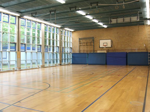 Leere Sporthalle mit Fensterfront
