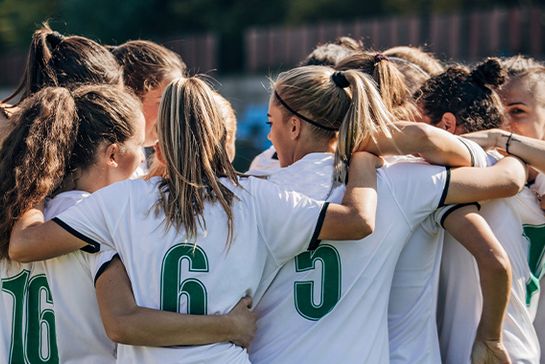 Frauen-Fußballmannschaft bildet einen Kreis.