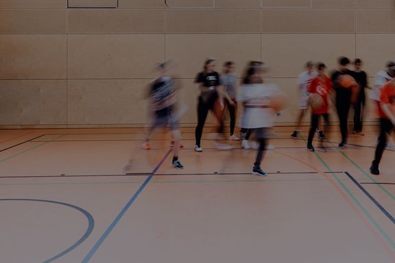 spielende Schüler*innen in Sporthalle
