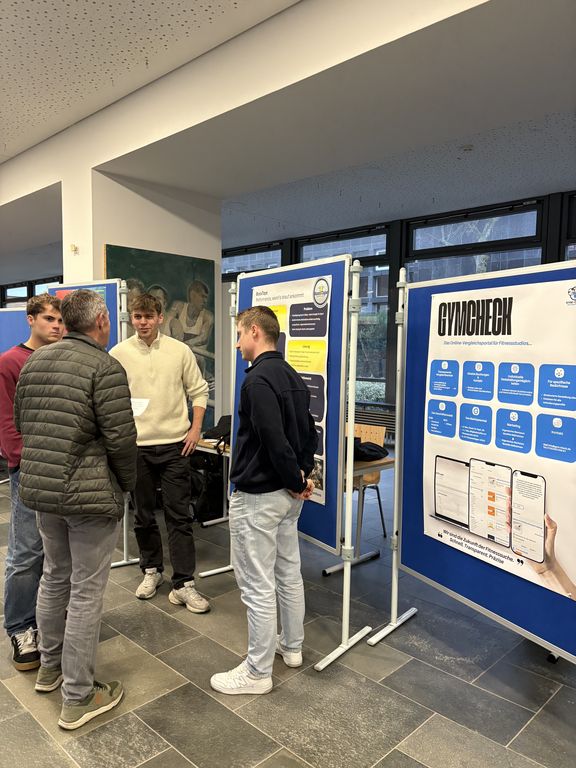 Personen stehen vor einer Plakatausstellung
