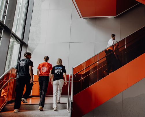 Studierende gehen eine Treppe in einem Gebäude der Deutschen Sporthochschule hoch
