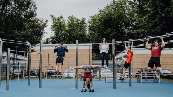 Foto von einigen Personen die Übungen an Gerüsten in Calisthenics Park machen
