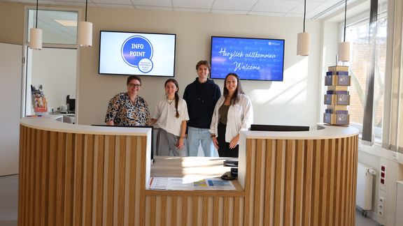 Das Bild zeigt vier Personen hinter einem Counter
