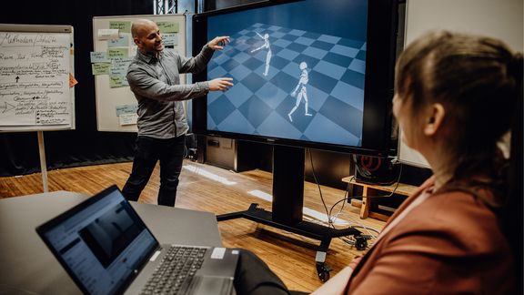 Dozent präsentiert 3-D-Skelette auf großem Monitor
