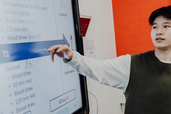 Person stellt Präsentation am großen Monitor vor