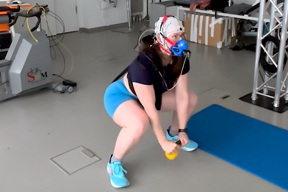 Probandin mit Spiromaske und Neurokappe bei einem Squat
