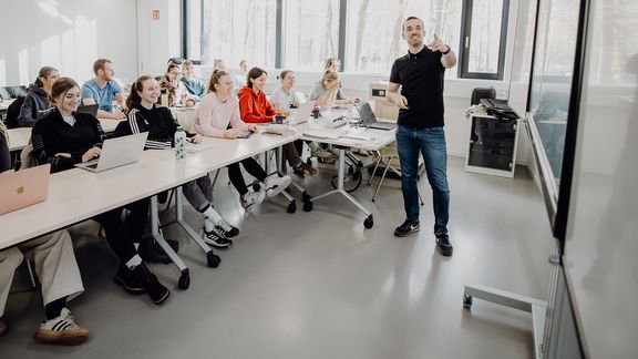 Dozent unterrichtet Studierende im Seminarraum
