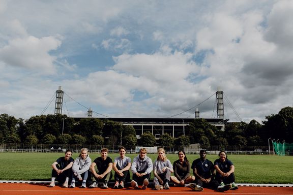 Studierende sitzen vor dem Rheinenergiestadion
