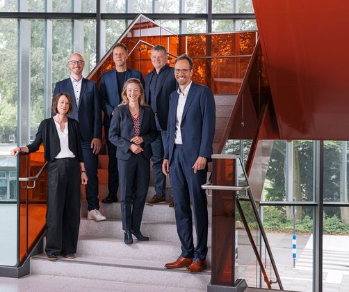 Rektorat der Deutschen Sporthochschule steht auf einer Treppe im Innenbereich des Campus

