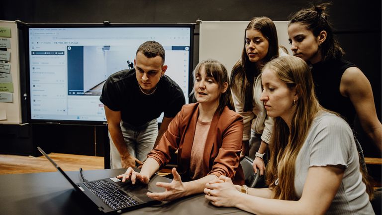 Personen betrachten Inhalte auf einem Laptop
