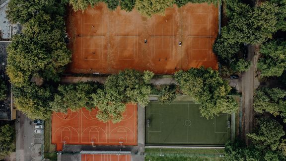 Drohnenansicht von Kunstrase, Basketballplatz und Tennisplätzen der Sporthochschule
