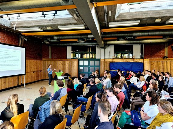 Sabine Reuker während ihrer Präsentation vor einer Gruppe Menschen
