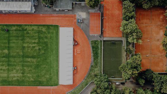 Drohnenansicht vom Leichtathletik-Stadion, den Tennis-Plätzen und Kunstrasenplatz der Sporthochschule
