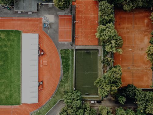 Drohnenansicht vom Leichtathletik-Stadion, den Tennis-Plätzen und Kunstrasenplatz der Sporthochschule
