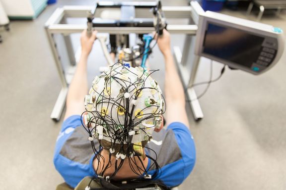 Person mit Neuronenkappe beim Handcycling.
